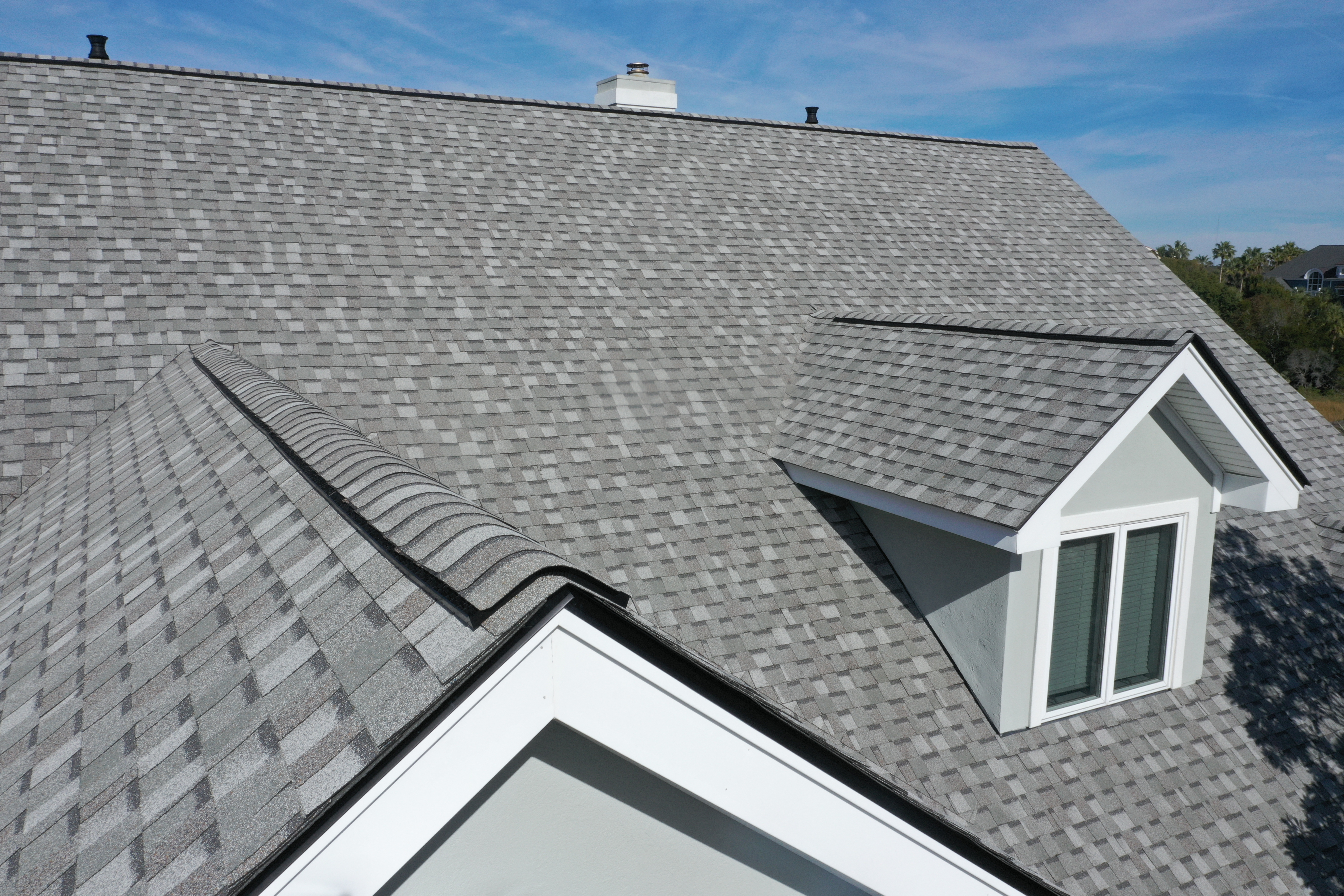 Close-up of architectural asphalt shingle roof ridges and dormers